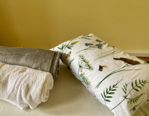 Entspannungsraum mit Yoga-Matte, Handtüchern und Naturmotiven.
